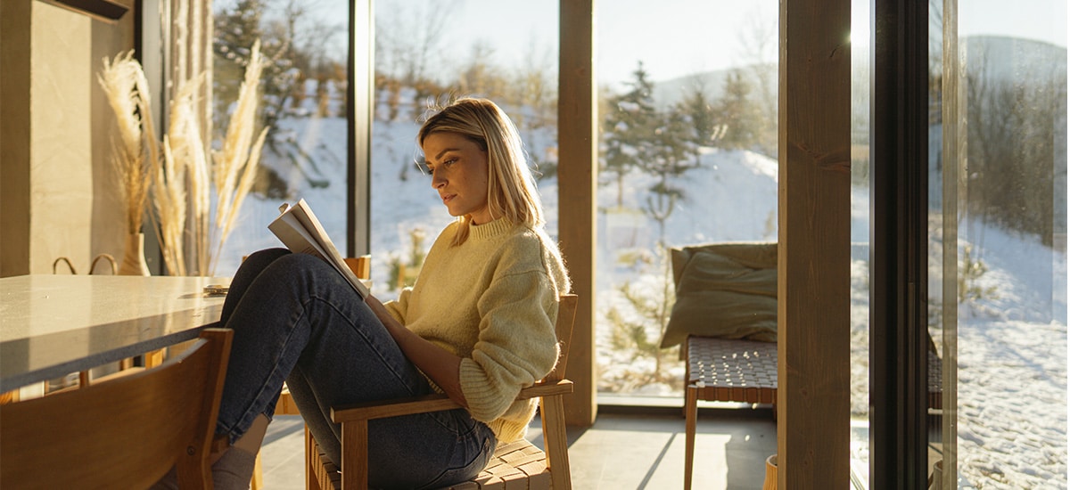 Foto av kvinne som leser i vinteromgivelser